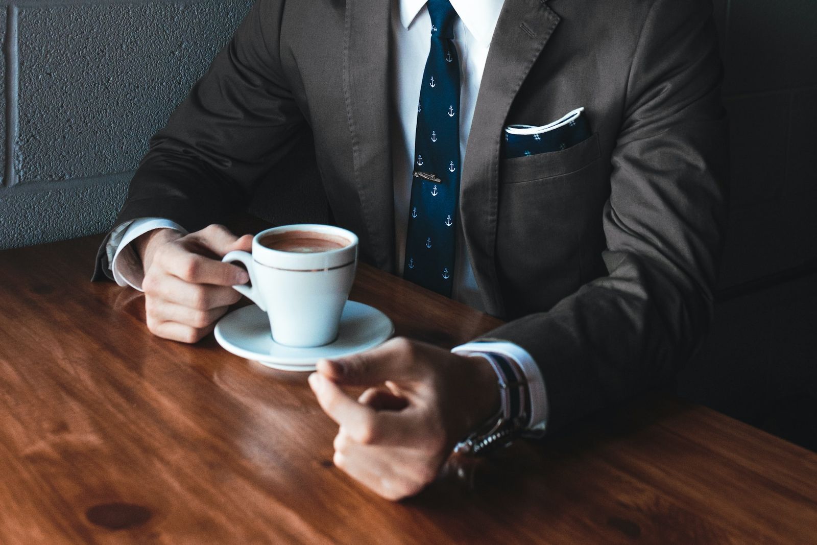 A man in a business suit drinking coffee