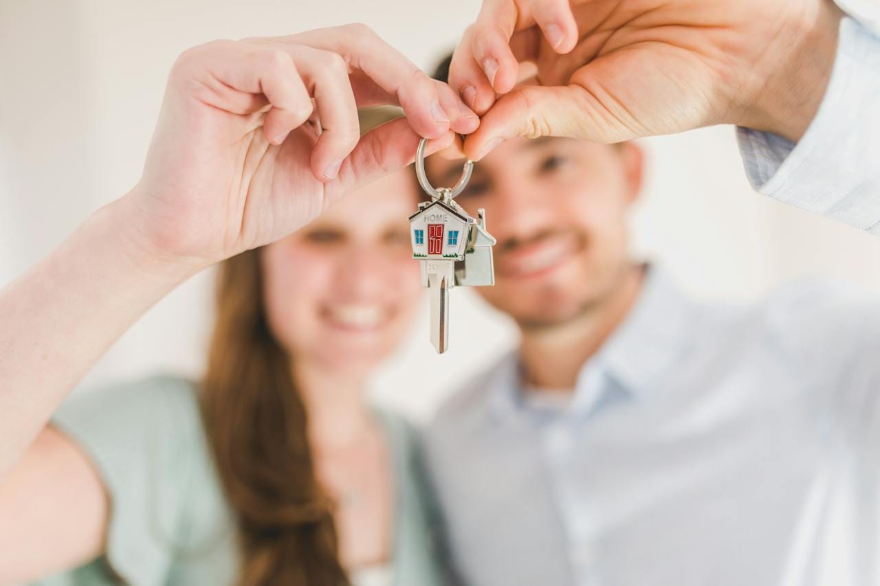 A happy couple holding on to the keys of a brand new home